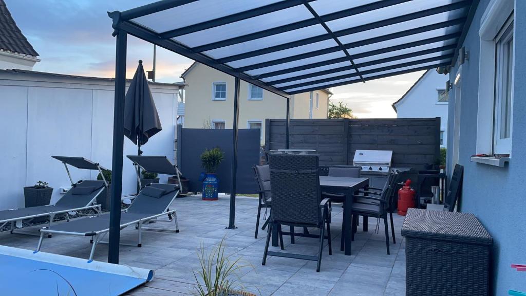 a patio with chairs and a table and an umbrella at modern house with pool - 3 bedrooms 2 Bathrooms in Memmingen