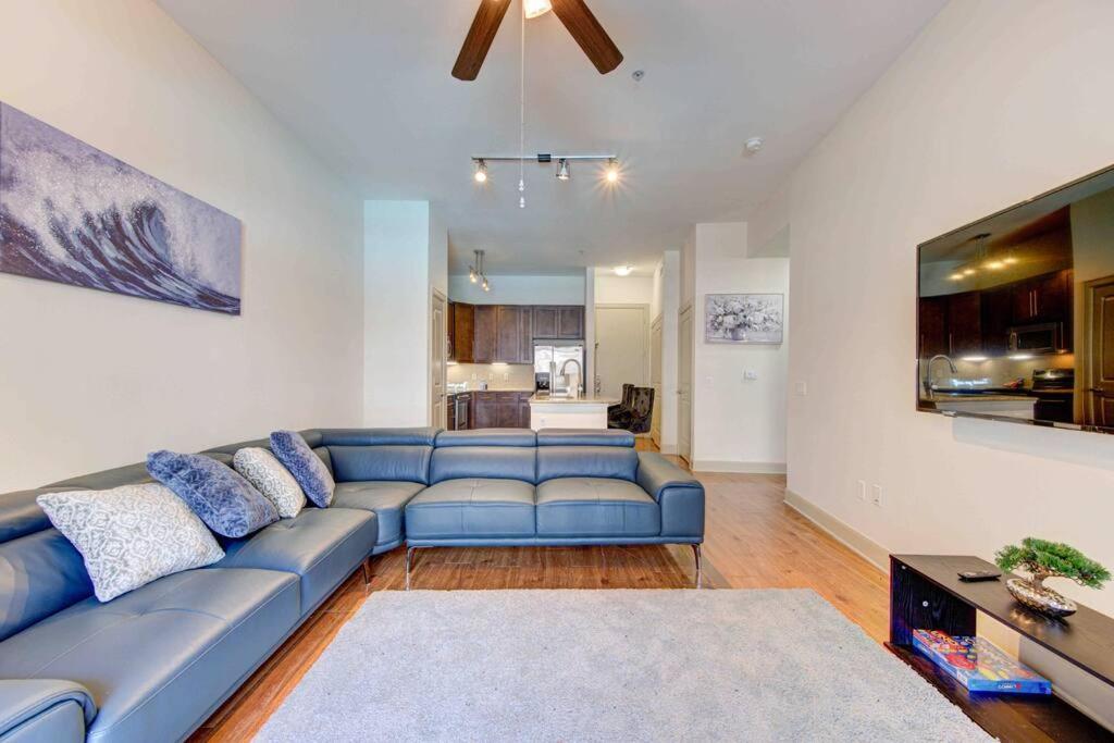 sala de estar con sofá azul y cocina en Houston Texas 1BR APT With pool view near NRG and MED CENTER en Houston