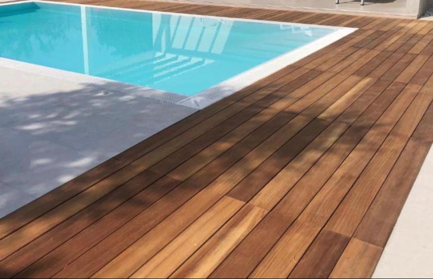 een zwembad met houten vloeren en een geheel zwembad bij Home sweet Home in SantʼAntonio Abate