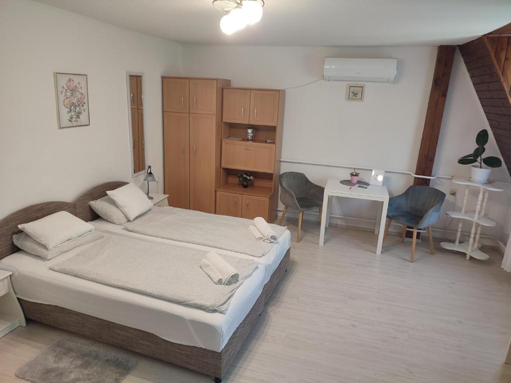 1 dormitorio con 1 cama, mesa y sillas en Veronika Rooms, en Hévíz