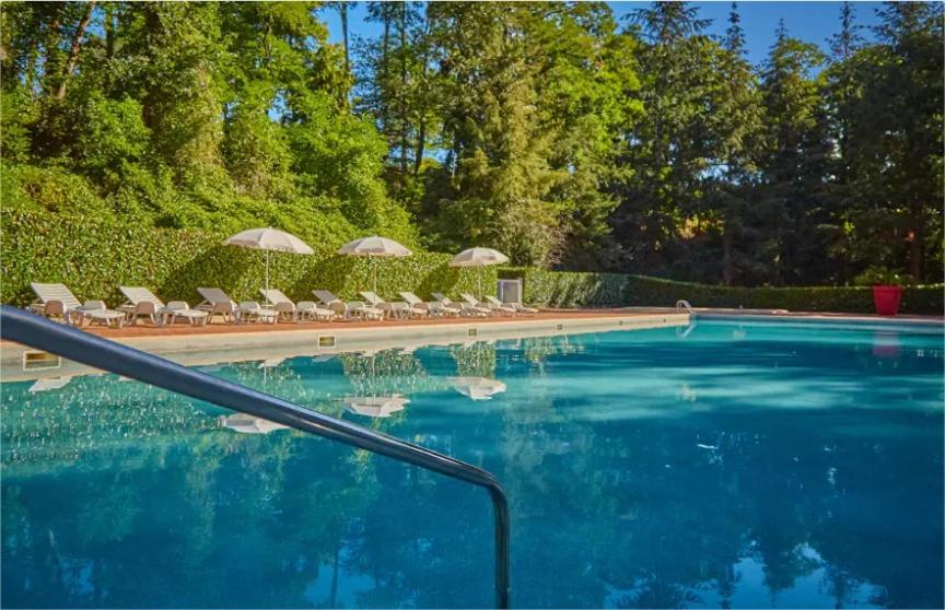 une piscine avec chaises longues et parasols dans l'établissement Mobile Home ~ Parc des Roches, à Saint-Chéron