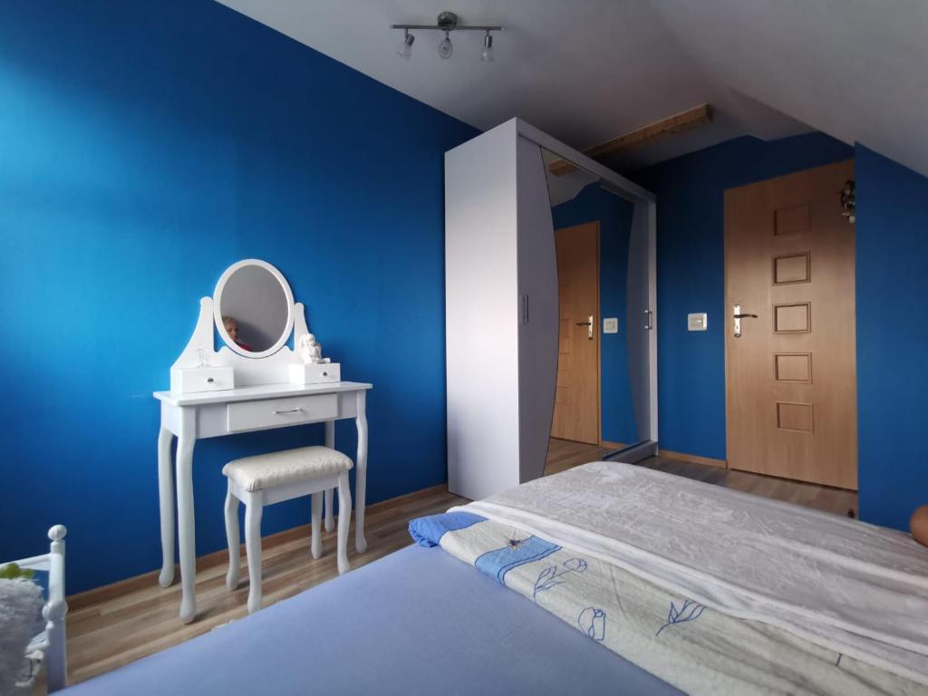 a blue bedroom with a dressing table and a mirror at Widok na Śnieżkę in Miłków