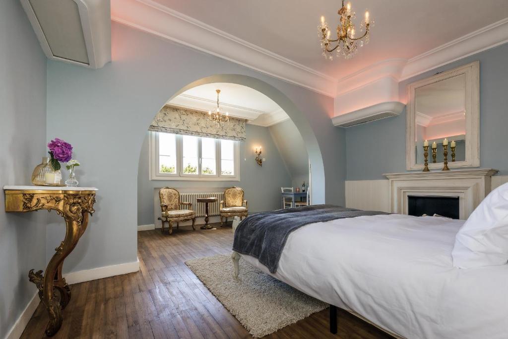 a bedroom with a large bed and a chandelier at Villa Verte in Saint-Mathieu