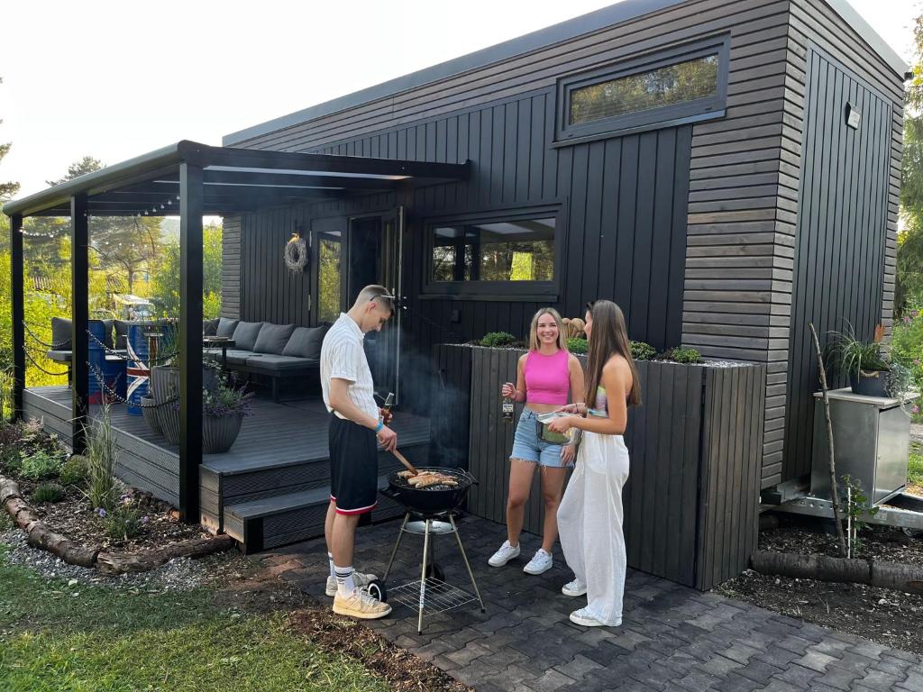 un grupo de personas de pie fuera de una casa pequeña en Sea Side Tiny House London, en Salzhemmendorf