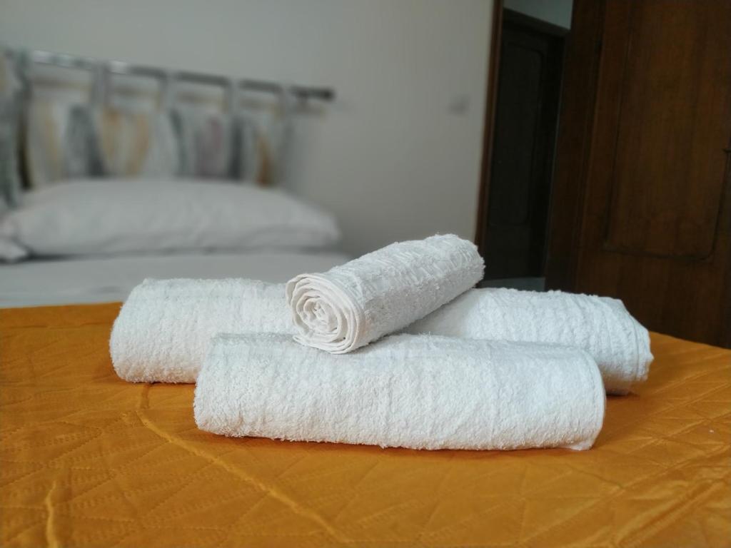 três rolos de toalhas brancas sentados numa mesa em "Babbo" Nicola em Salve