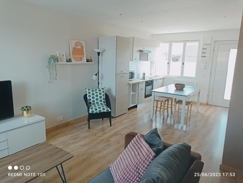 a living room with a couch and a table at Spacieux appartement en duplex in Merlimont