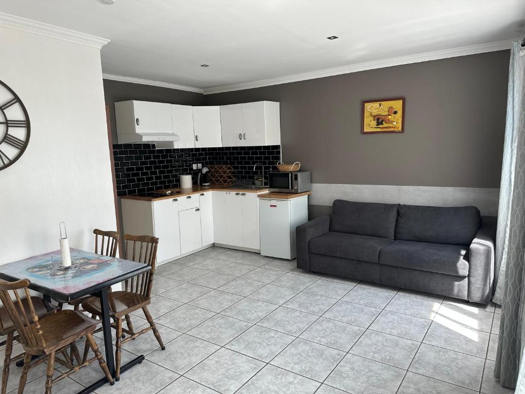 cocina y sala de estar con sofá y mesa en Logement meublé avec terrasse, en Vincennes