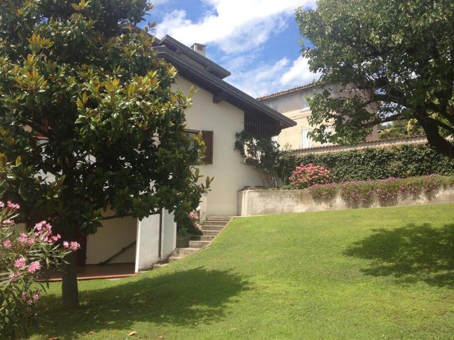 une maison blanche avec une cour dotée d'une pelouse dans l'établissement Charming Villa in Monferrato, à Camino
