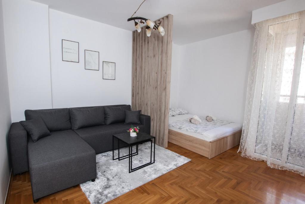 een woonkamer met een bank en een tafel bij Apartman Vas dom 2 in Kraljevo