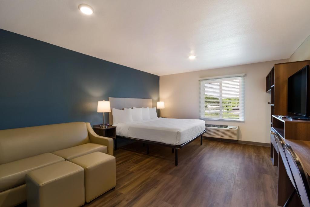 una camera con letto, divano e TV di WoodSpring Suites Panama City Beach a Panama City Beach