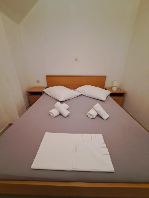 a bed with two pillows and two towels on it at Apartmani ante 3 in Drašnice