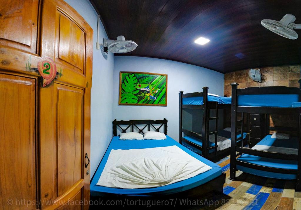um quarto com uma cama e 2 beliches em Hostel Tortuguero 7BackPackers em Tortuguero
