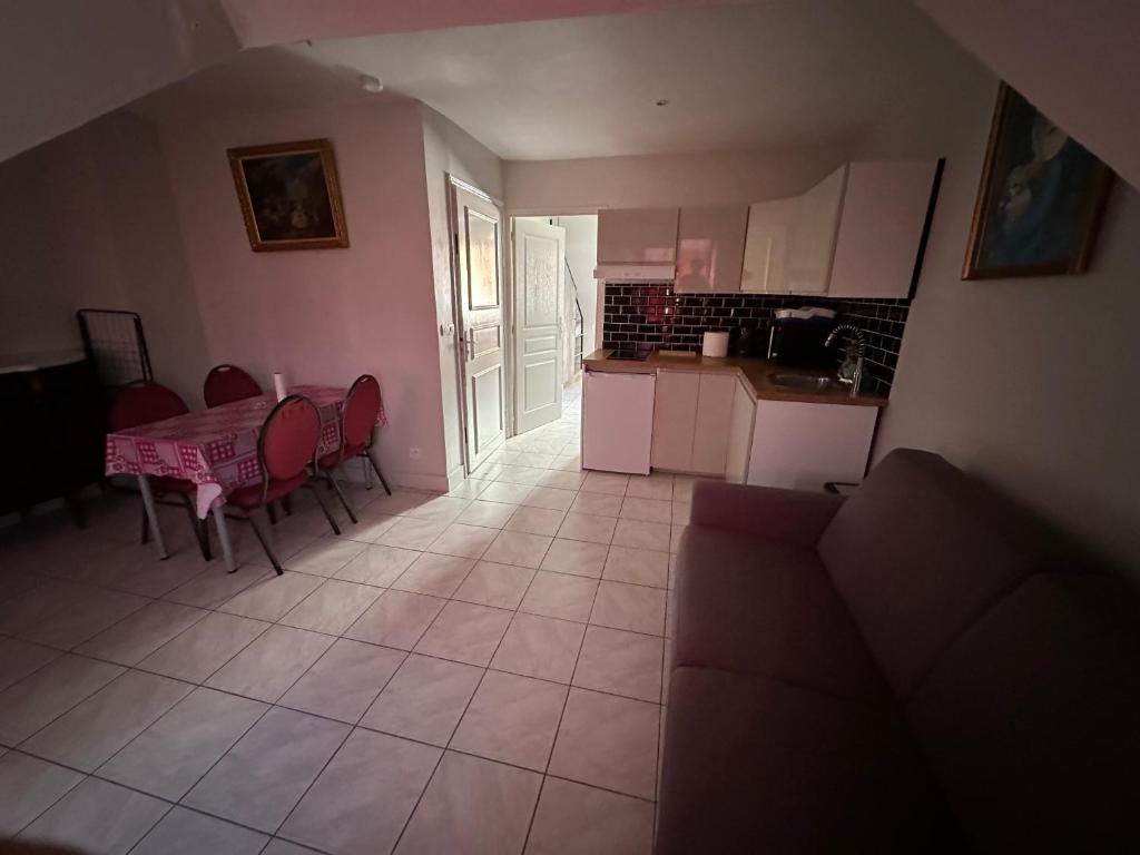 ein Wohnzimmer mit einem Tisch und einer Küche in der Unterkunft appartement meublé in Vincennes