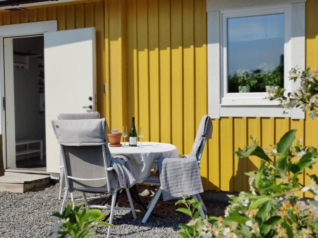 uma mesa e duas cadeiras em frente a uma parede amarela em Gästhus nära naturen em Holmsund