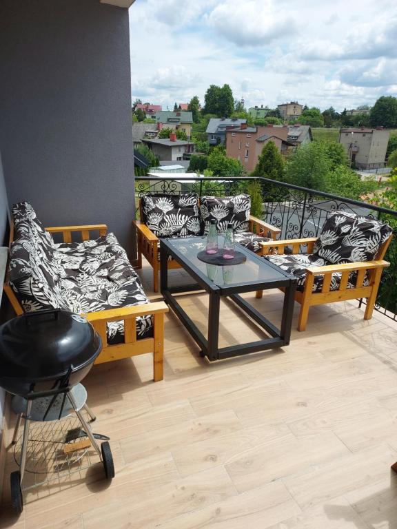 a balcony with a table and chairs on a balcony at Apartament Świerkowa in Lidzbark