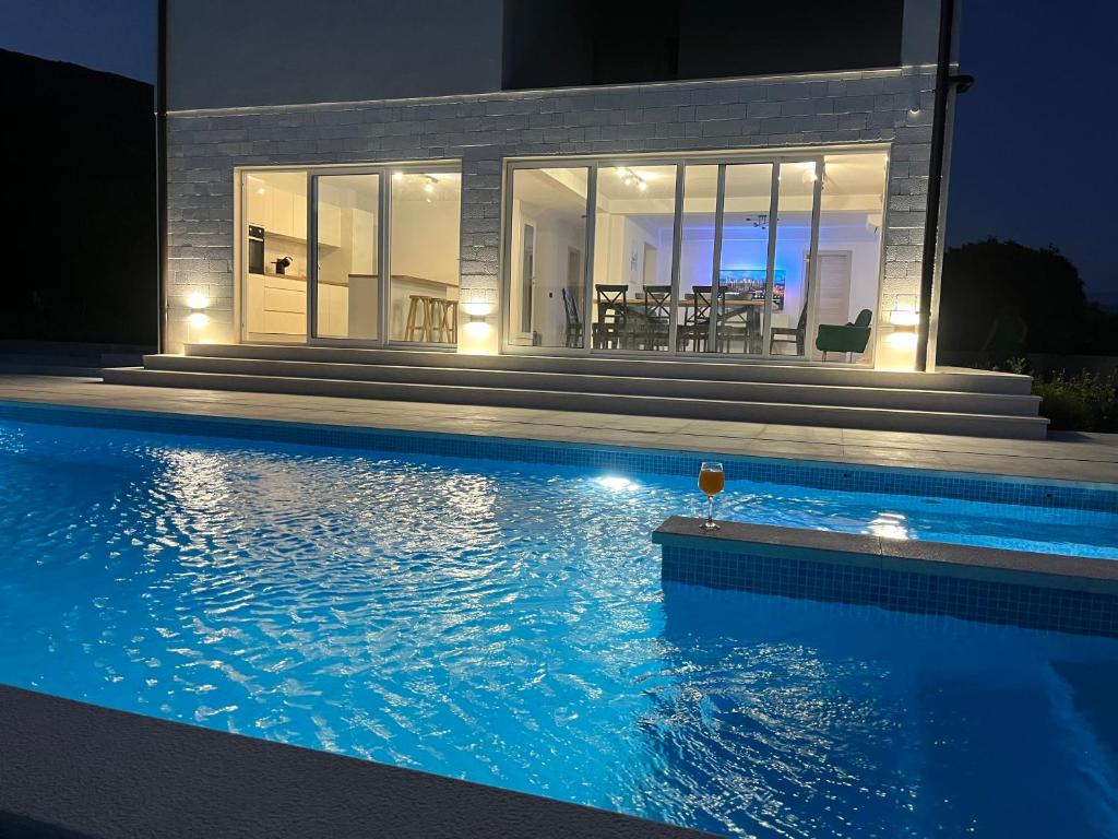 a house with a swimming pool at night at BAVA in Kaštela