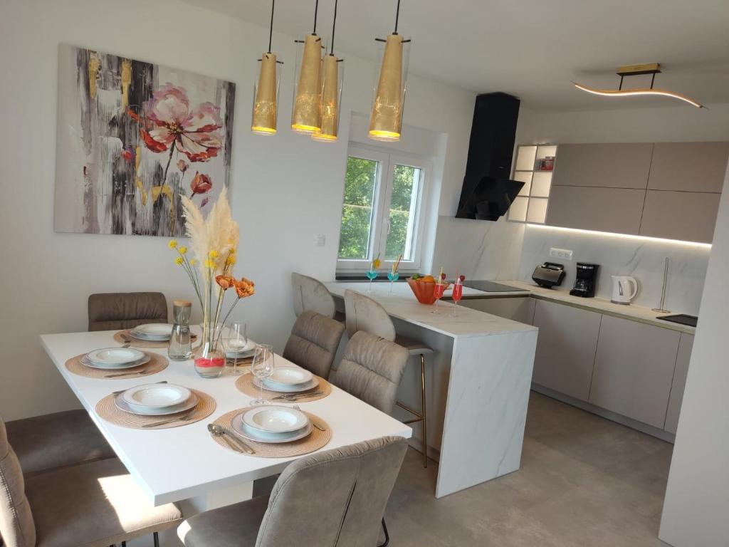 a kitchen and dining room with a white table and chairs at Lunisa VS1 Apartment in Kostrena