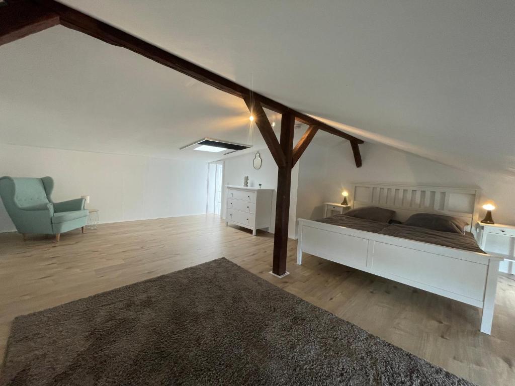 Weißes Schlafzimmer mit blauem Sessel