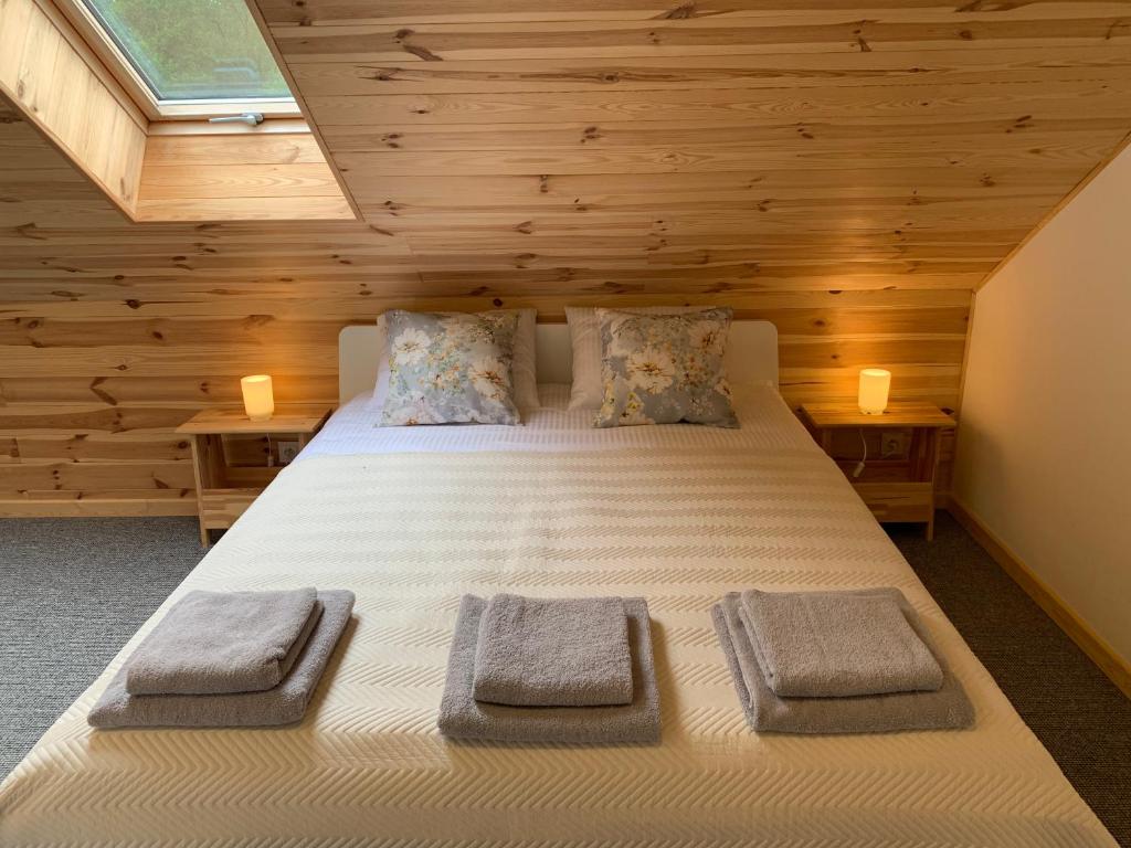 a bedroom with a large bed with wooden walls at Modrzewiowe Zacisze in Chocieszow