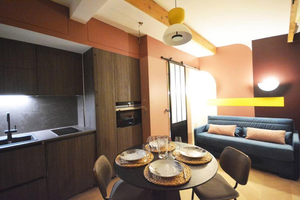 cocina y comedor con mesa y sillas en Appartement design à la bourse du commerce, en París