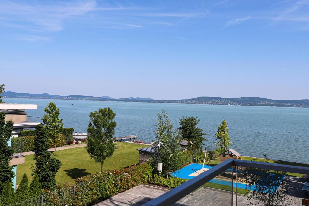 a view of the water from the balcony of a house at Platán Beach Apartman in Balatonboglár