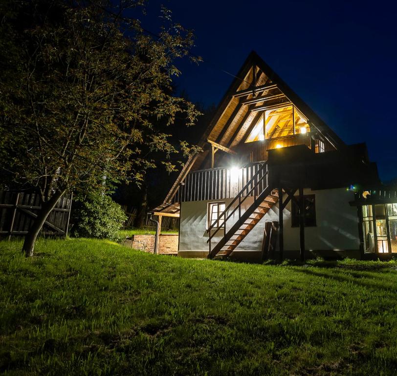 ein Haus in der Nacht mit Lichtern an der Seite in der Unterkunft Paradise Cottage - Chalupa v Ráji in Čtveřín