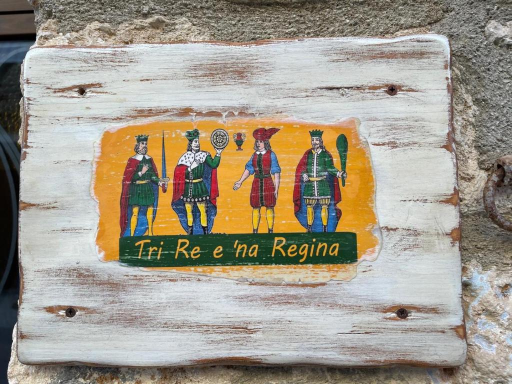 ein Schild an der Seite einer Wand mit einem Gemälde in der Unterkunft Tri Re e 'na Regina in Cinisi