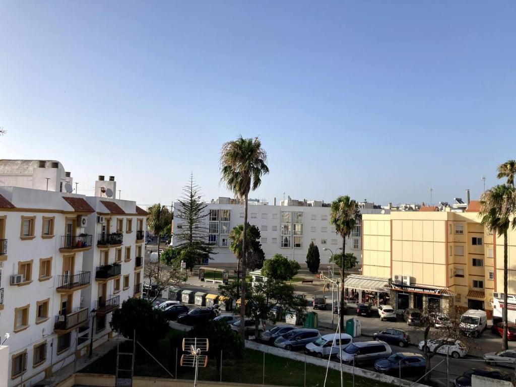 vistas a un aparcamiento con palmeras y edificios en Barragán 1, en Puerto Real