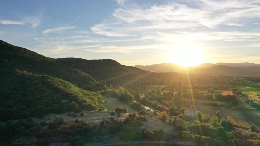 een luchtzicht op een vallei met zonsondergang bij Mas Grenadine, magnifique villa du Piémont Cévenol in Sauve