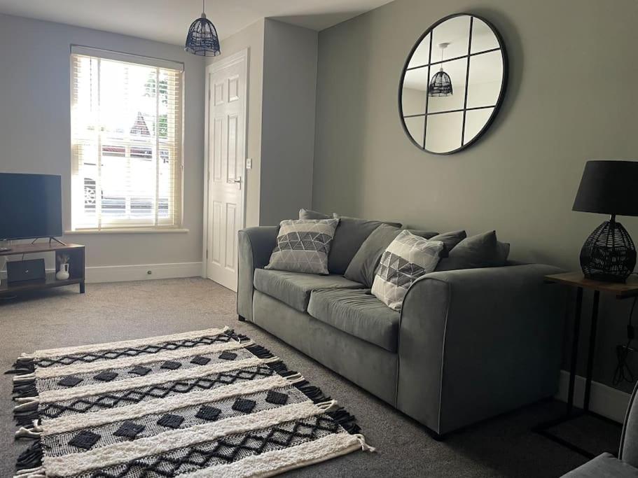 a living room with a couch and a mirror at Oak House - 3bed Townhouse with free parking by ShortStays4U in King's Lynn