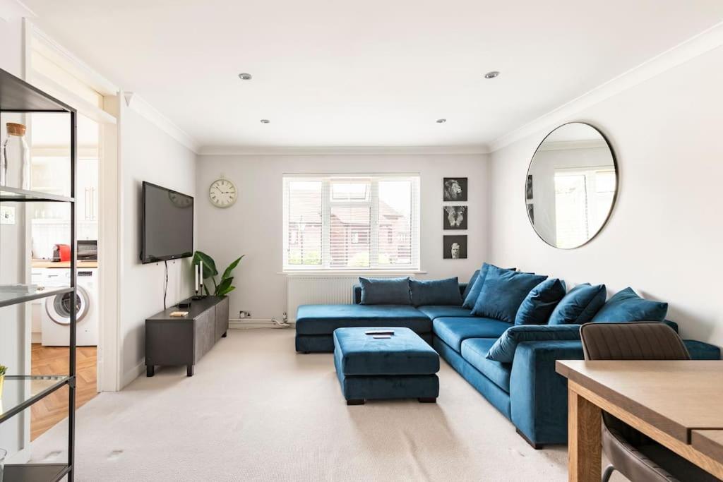 a living room with a blue couch and a tv at Spacious light flat in fantastic location! in Eton