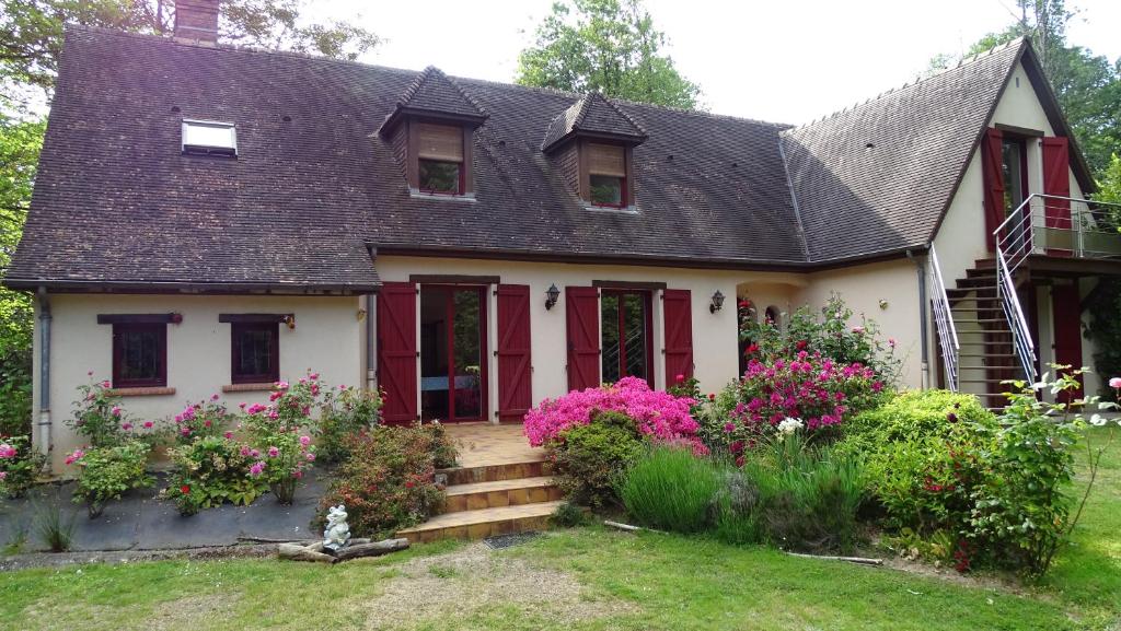 ein Haus mit rosa Blumen im Hof in der Unterkunft Chambres de Monthéard in La Bazoge