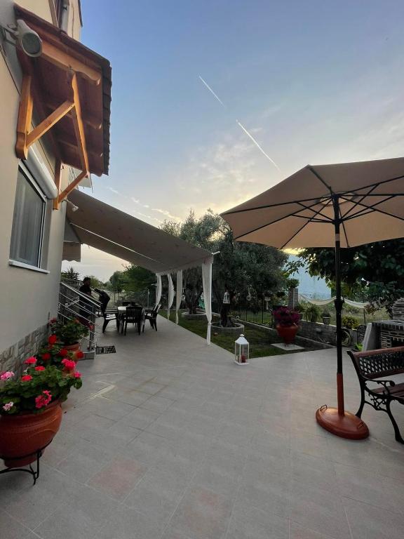 a patio with an umbrella and chairs and tables at Backyard houses in Toroni