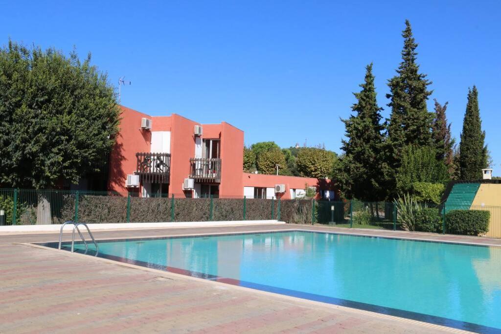 une piscine devant un immeuble dans l'établissement Appartement 1903 Tennis Village, au Cap d'Agde