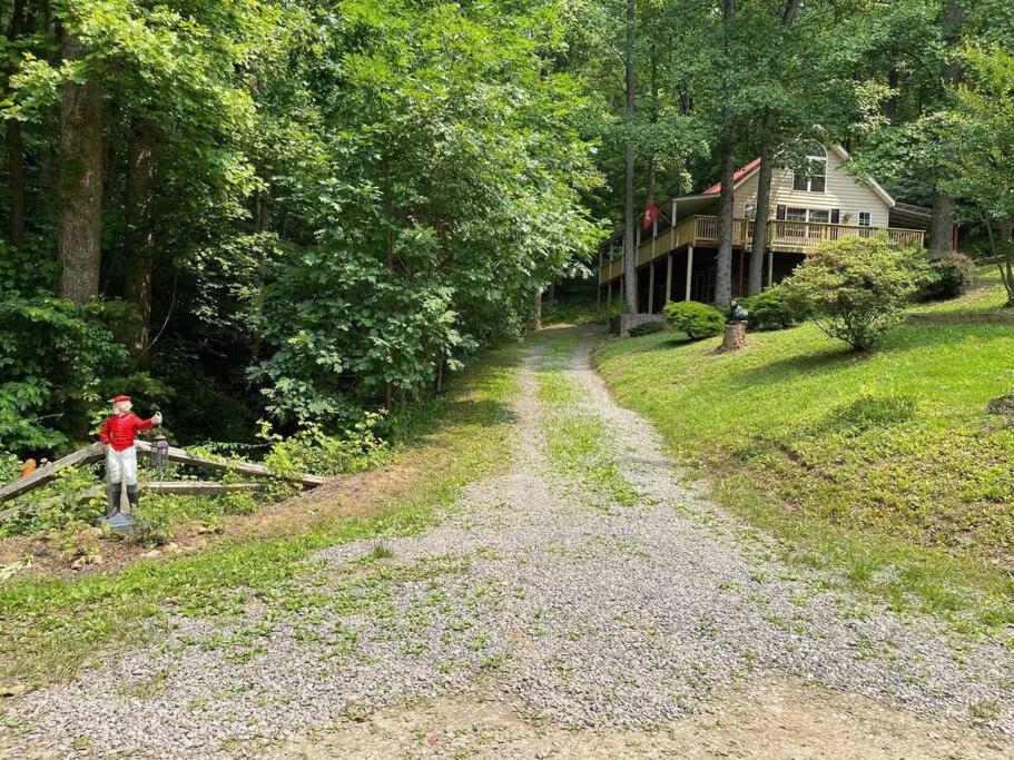 um homem parado numa estrada de terra em frente a uma casa em Dogwood Mountain House em Fancy Gap