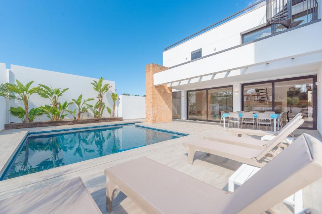 uma villa com uma piscina e uma casa em Villa Sa Marinada | 100m de Mar em San Jose de sa Talaia