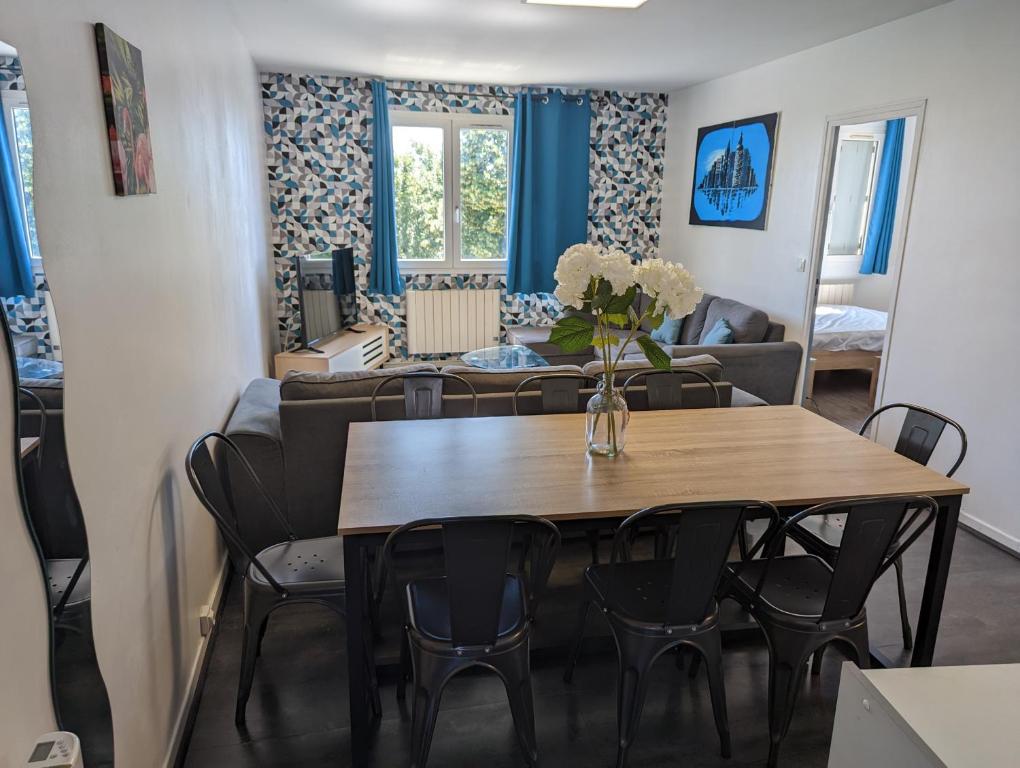 - une salle à manger et un salon avec une table et des chaises dans l'établissement Appartement meublé proche du futuroscope, à Poitiers