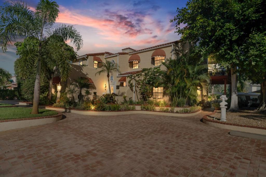 a building with palm trees in front of a driveway at Banyan House Vacation Rentals in Venice