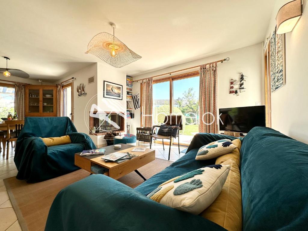 sala de estar con sofá azul y mesa en Maison de vacances tout confort - 500m des plages, en Locmariaquer