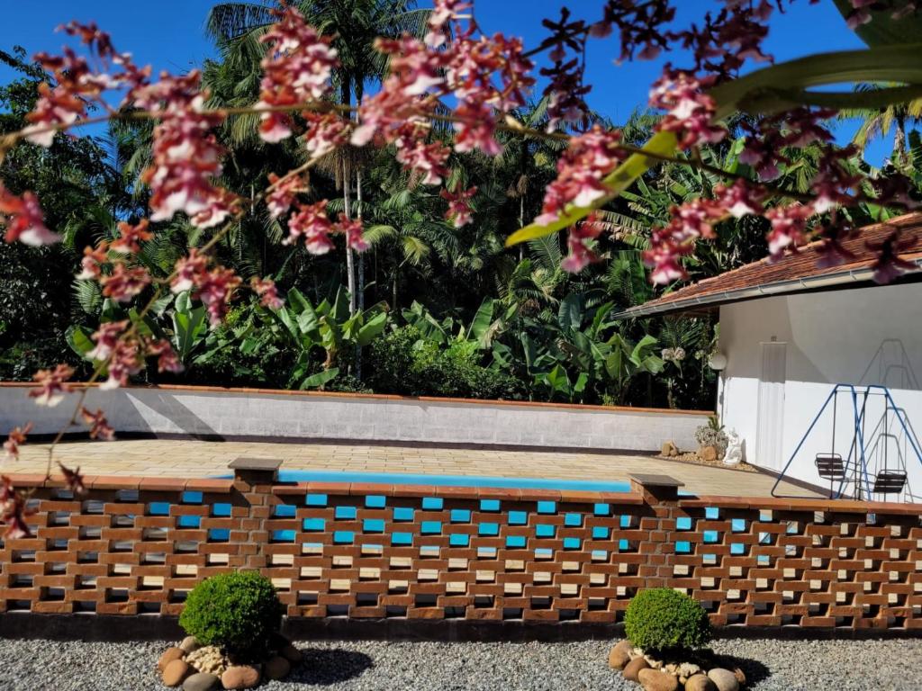 eine Holzbank vor einem Garten mit Blumen in der Unterkunft Espaço Wunder Platz in Pomerode