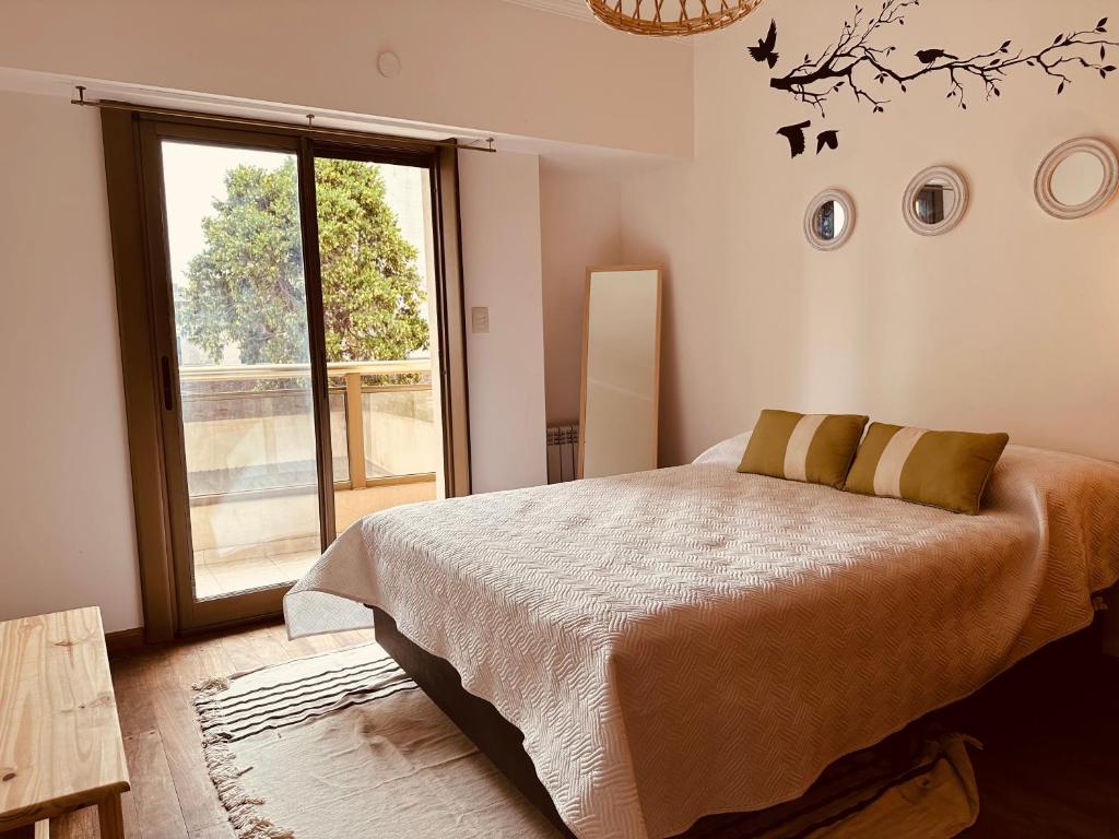 een slaapkamer met een bed en een groot raam bij Depto Categoria Zona Plaza Italia con opcion de cochera By Lofter in La Plata