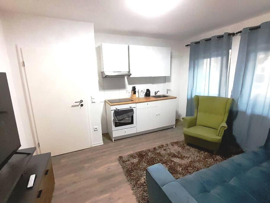 a living room with a blue couch and a kitchen at Schöne Klasse Apartment nähe Veltins Arena in Gelsenkirchen