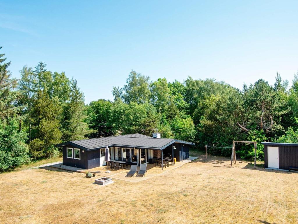 a black tiny house in the middle of a field at 7 person holiday home in Grenaa in Grenå