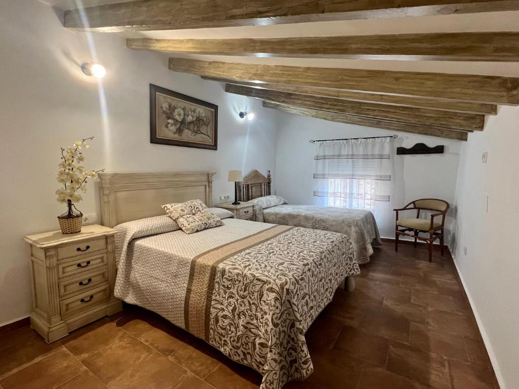 a bedroom with two beds and a wooden ceiling at Casa rural Las Casillas in Málaga