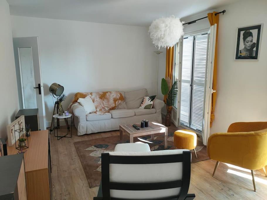 - un salon avec un canapé et une table dans l'établissement Maison avec jardin Auxerre, à Saint-Georges-sur-Baulche