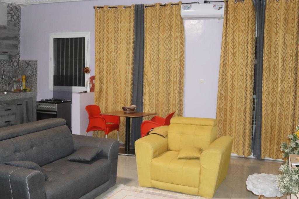 uma sala de estar com um sofá e uma cadeira amarela em Résidences PRIMIS Thiès - appartements et chambres em Thiès