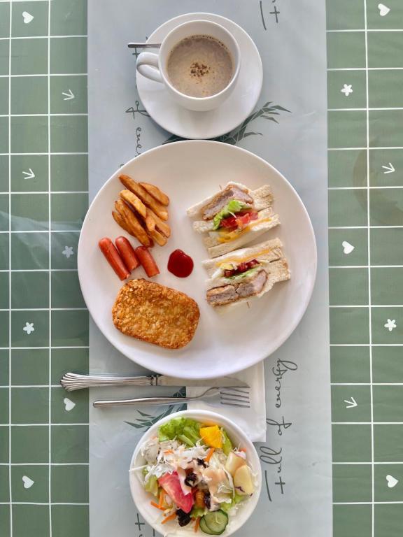 a table with two plates of food and a cup of coffee at Wenpin Hotel - Pier 2 in Kaohsiung