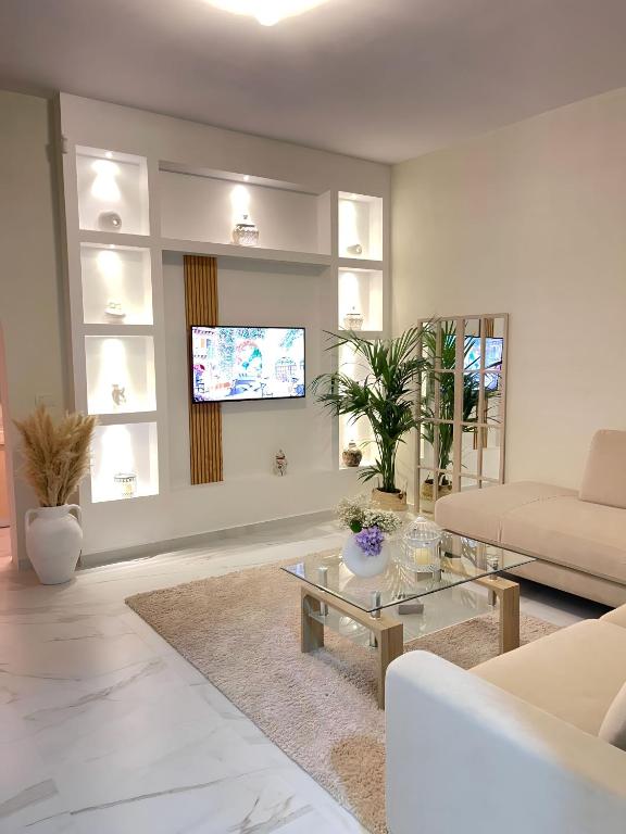 a living room with a couch and a tv at Mediterranean Villa Old Town in Vlorë