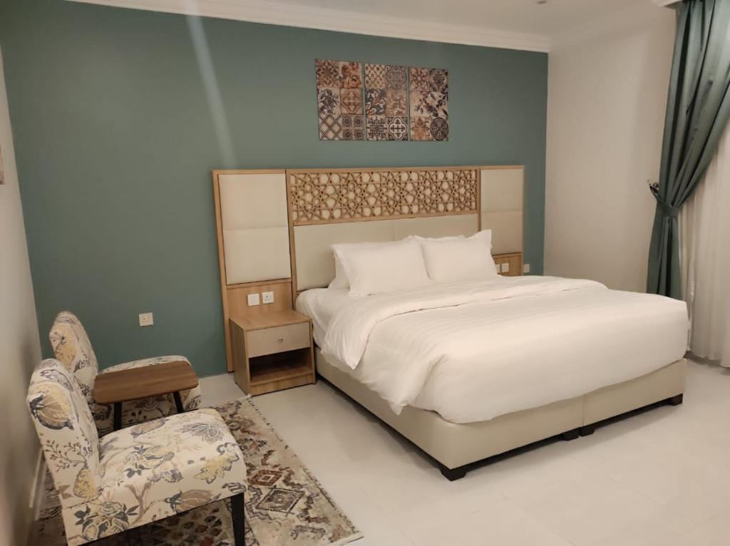 a bedroom with a large bed and a chair at Kyan Park Abha Hotel in Abha