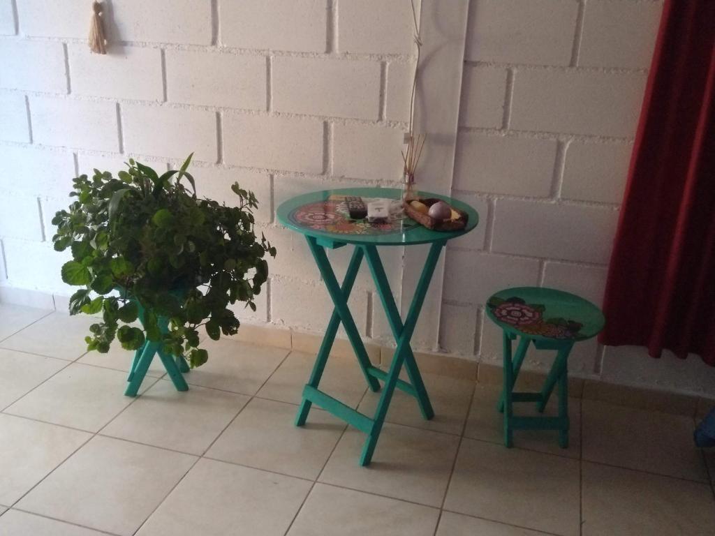 a green table and two stools next to a wall at El secreto de la vida in Villa de Soto